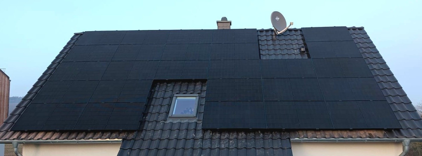 Große Photovoltaikanlage auf Wohnhausdach mit schwarzen Modulen
