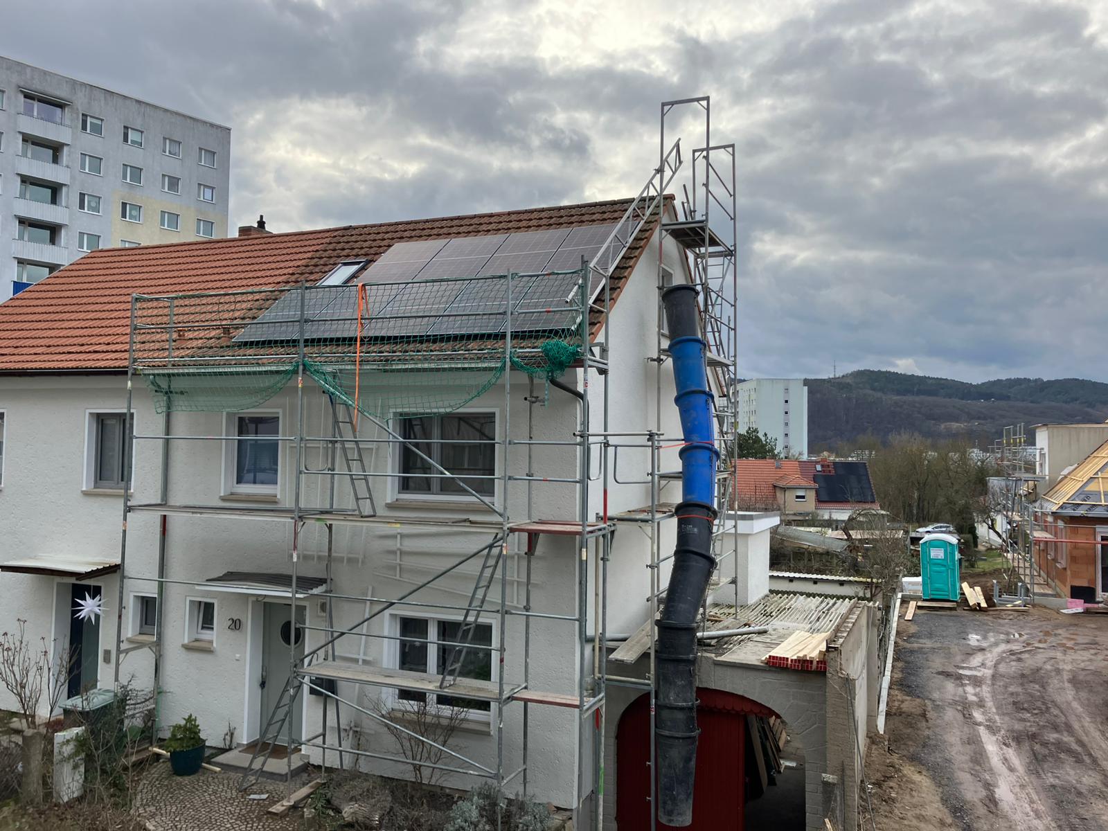 Haus mit aufgebautem Gerüst für Photovoltaik-Montage
